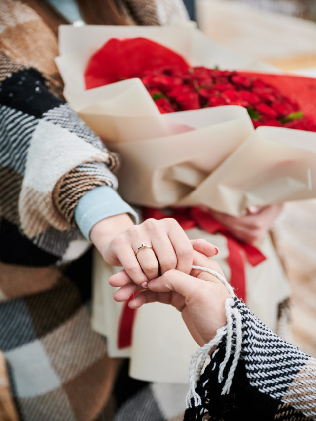 Man in love holding girlfriend hand with engagement ring.